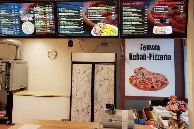 Sisäkuva Teuvan kebab-pizzeriasta, kuvassa hinnasto ja myyntitiski.