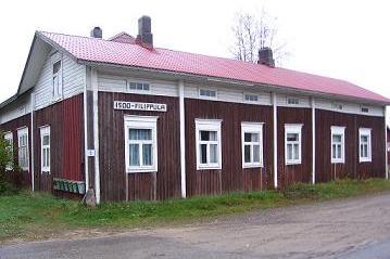 Kuvassa vanha puna-valkoinen maalaistalo.