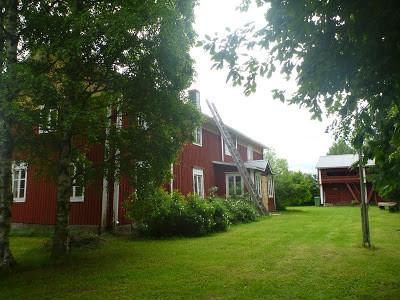 Museon piha. Vasemmalla reunalla punainen museorakennus, taka-alalla aitta.